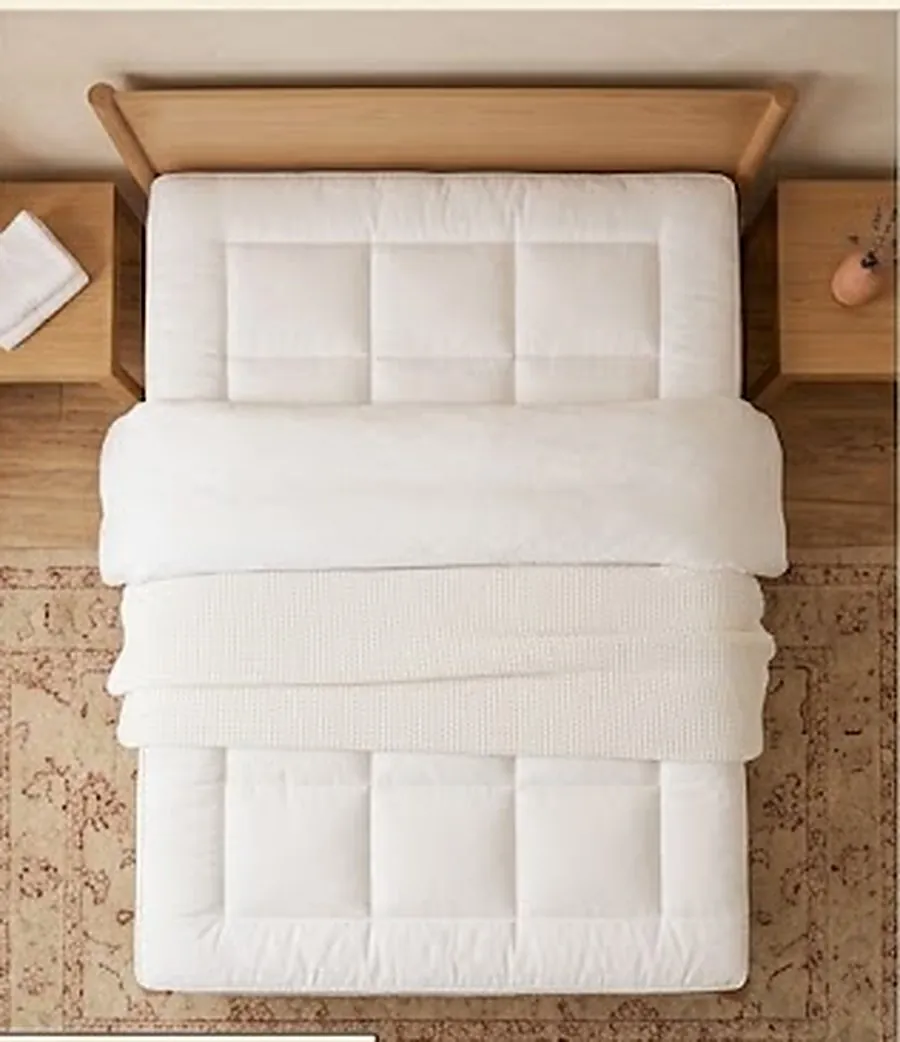 Chambre en lumière chaude, literie claire et plaid terracotta